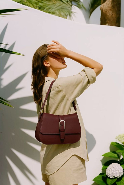 Woman carrying a burgundy leather shoulder bag